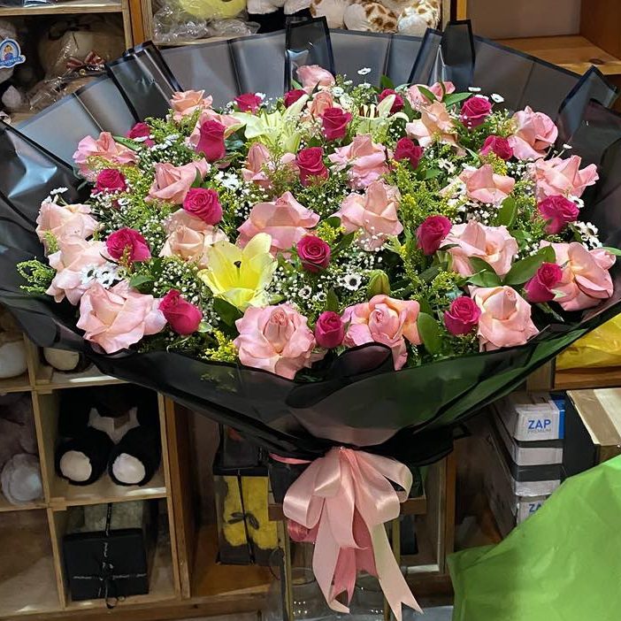 Ramo buchón de rosas rosa, fucsia y lilys en papel negro