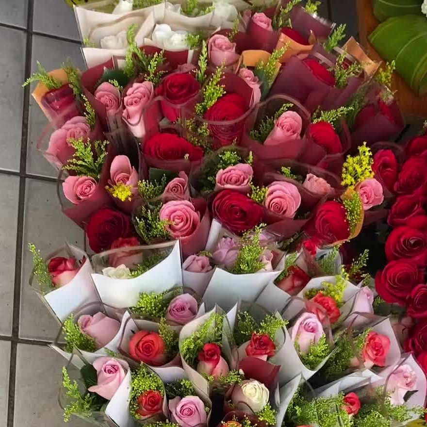 Decenas de ramos de rosas rosas y rojas listos para entrega